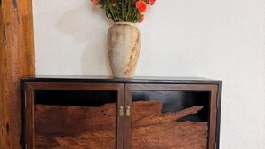A wooden cabinet with a vase of flowers on top. - Youdu Inn (Dali City)