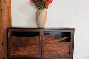A wooden cabinet with a vase of flowers on top. - Youdu Inn (Dali City)