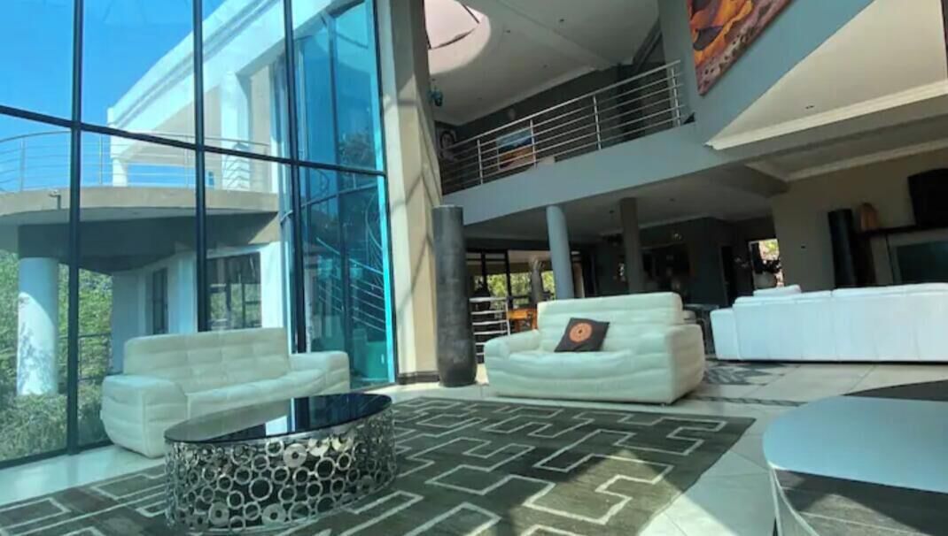 A spacious lobby with a high ceiling, a large glass wall, and a modern white sofa.