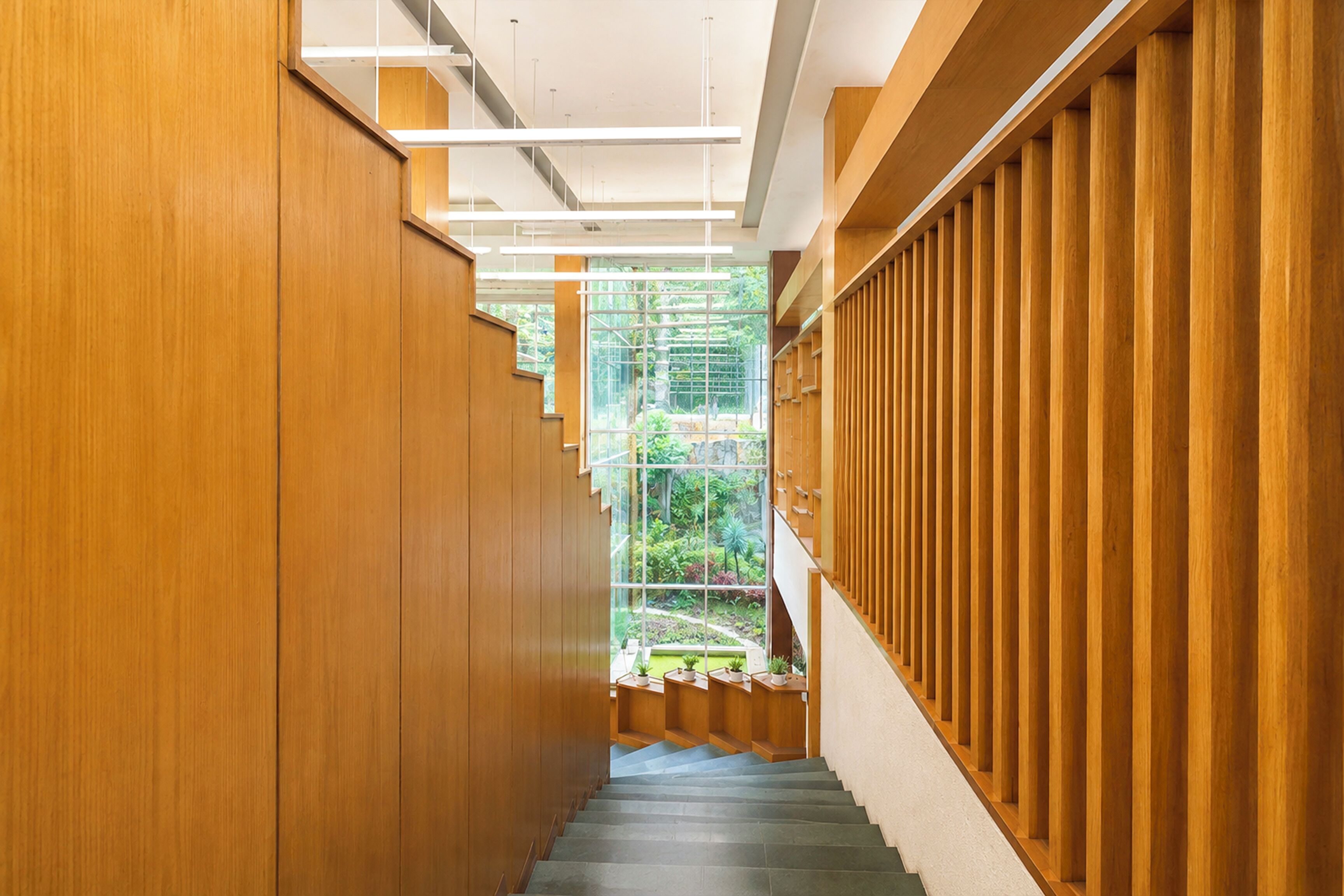 Un pasillo interior de madera con una escalera que lleva a un conservatorio.