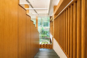 A wooden interior corridor with a staircase leading to a conservatory.