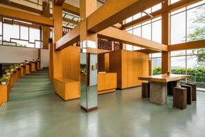 A spacious interior with a staircase, wooden furniture, and large windows.