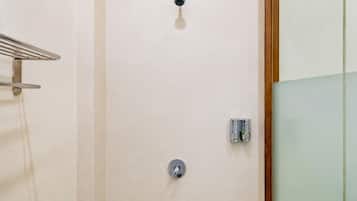 Ein Badezimmer mit Handtuchhalter, Duscharmatur und Glasabtrennung.