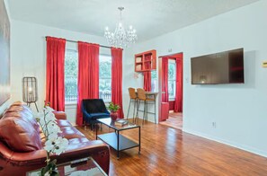 A living room with a sofa, coffee table, and a TV. - 1BR The Montrose W Main 02, Downtown, Med Center (Houston)