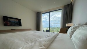 A hotel room with a large bed, a television on the wall, a balcony with a view, and a lamp. - Walk to Beach| lovely AP with pool for honeymoon (Da Nang)
