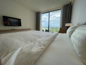 A hotel room with a large bed, a television on the wall, a balcony with a view, and a lamp. - Walk to Beach| lovely AP with pool for honeymoon (Da Nang)