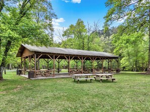 A rustic wooden pavilion with picnic tables in a forested park. - Charming Cabin in the clouds with hot tub, screen porch and fireplace (Ellijay)