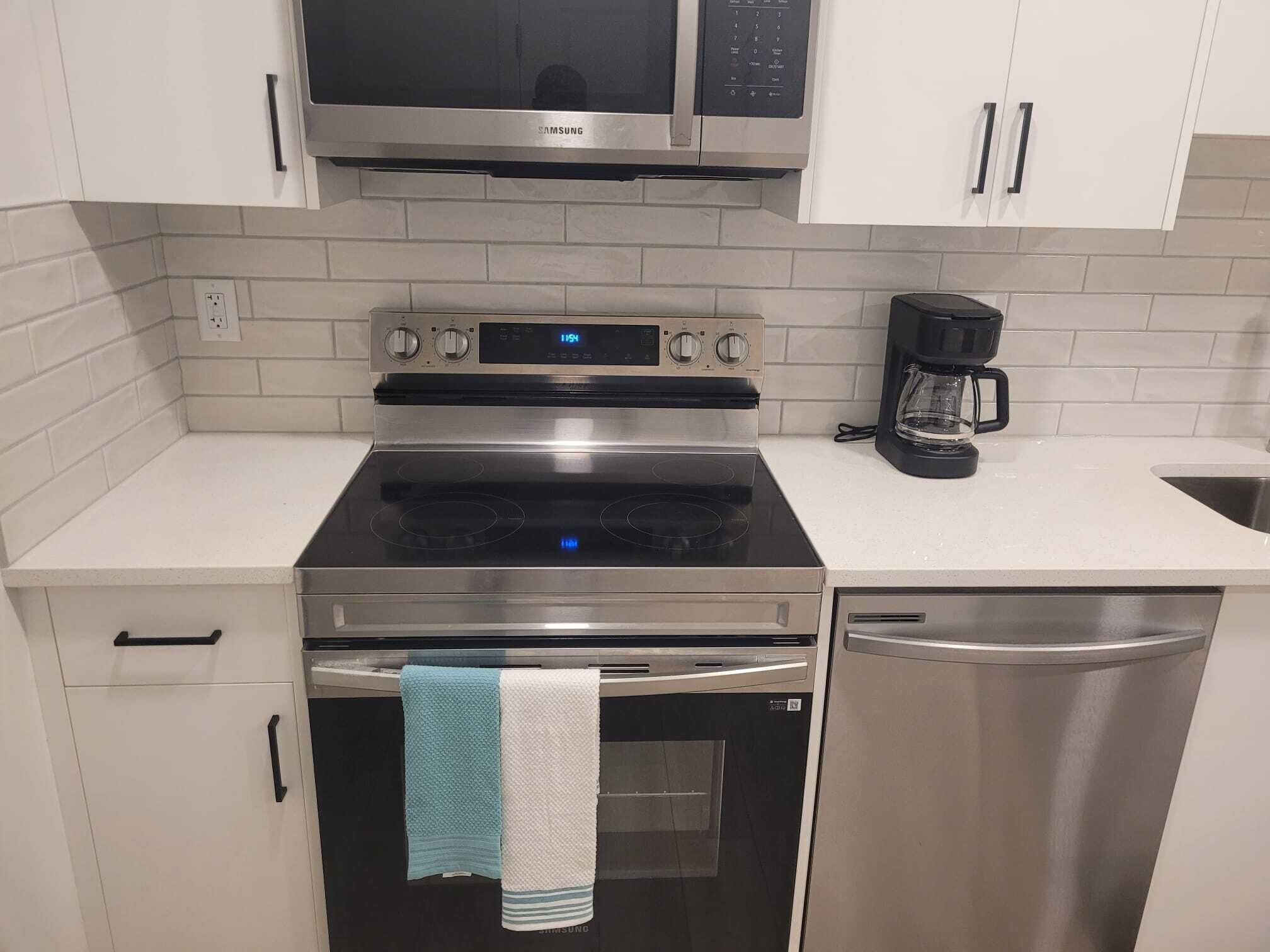 A modern kitchen with stainless steel appliances, including a microwave, oven, and dishwasher.
