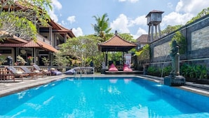 A swimming pool with lounge chairs and a gazebo.