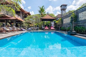 A swimming pool with lounge chairs and a gazebo.
