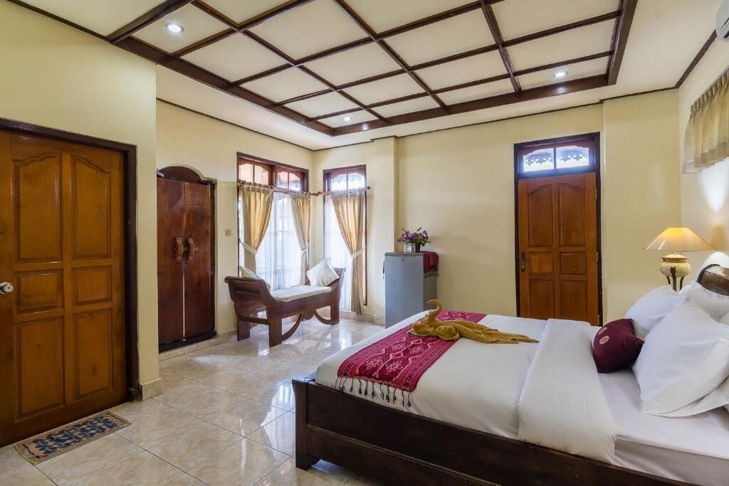 A hotel room with a bed, a desk, a chair, and a wardrobe.