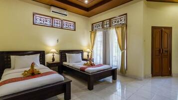 A hotel room with two beds, a wooden ceiling, and a large window with curtains.