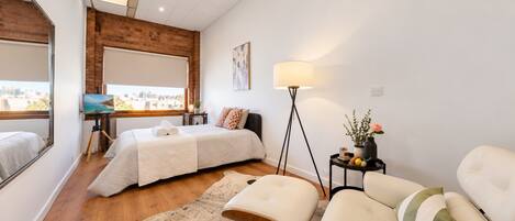Une chambre moderne avec un lit, un bureau, une chaise et une grande fenêtre.