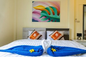 A hotel room with a bed, pillows, a painting, and a heart-shaped towel arrangement. - 4-bedroom bungalow in tranquil setting (Tambon Choeng Thale)