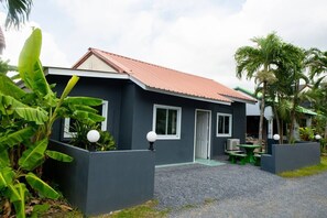 A modern two-story building with a red roof, surrounded by lush greenery and a gravel driveway. - 4-bedroom bungalow in tranquil setting (Tambon Choeng Thale)