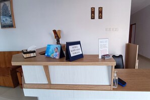 Un comptoir d’accueil avec une enseigne indiquant « SEIDA KOPIASILI TORAJA » et un petit panneau indiquant les informations relatives au Wi-Fi.