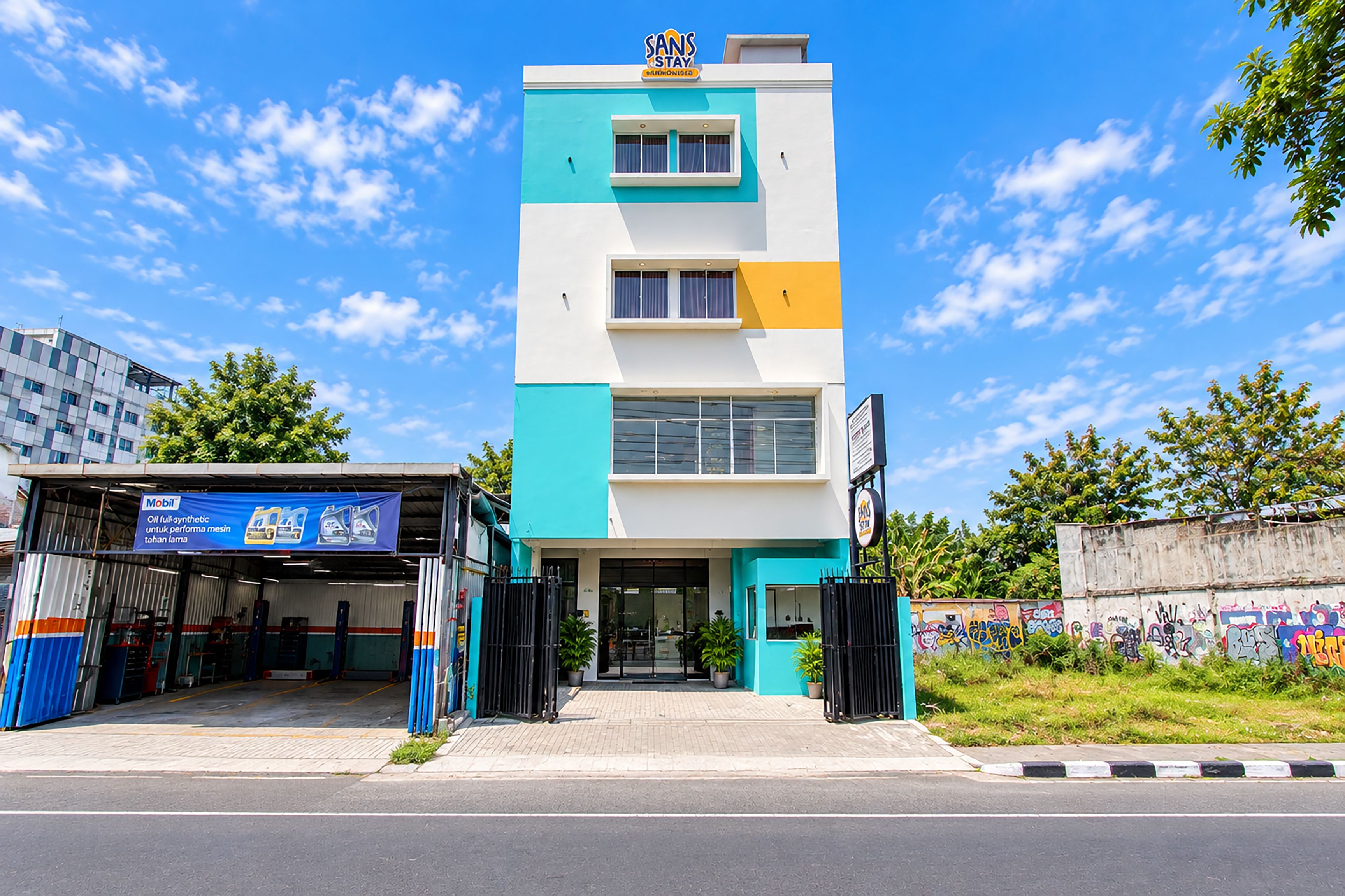 A multi-story building with a modern design, featuring a flat roof and a mix of white and teal colors.
