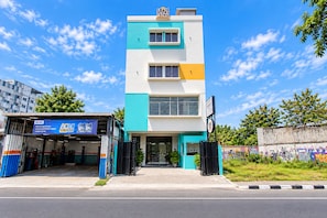 A multi-story building with a modern design, featuring a flat roof and a mix of white and teal colors. - Collection O near Adisutjipto Airport (Depok)