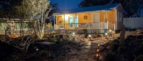 A house with a porch, stone pathway, and outdoor lighting.