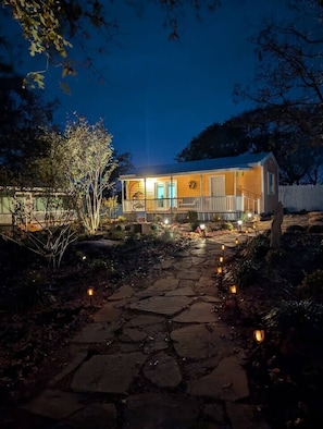 A house with a porch, stone pathway, and outdoor lighting.