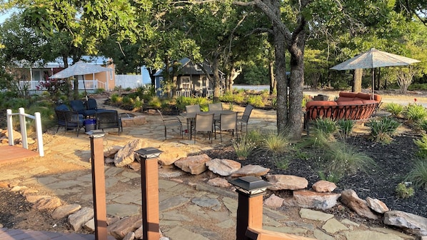 An outdoor patio area with stone flooring, seating arrangements, and a small water feature.