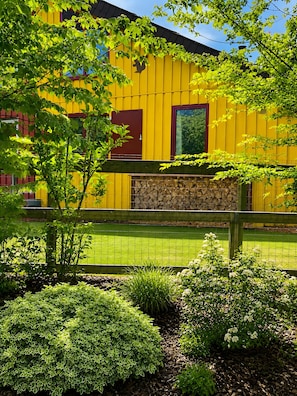 A yellow building with a stone wall and a fenced yard.