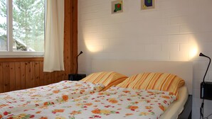 A double bed with floral bedding, a wooden headboard, and two bedside lamps.
