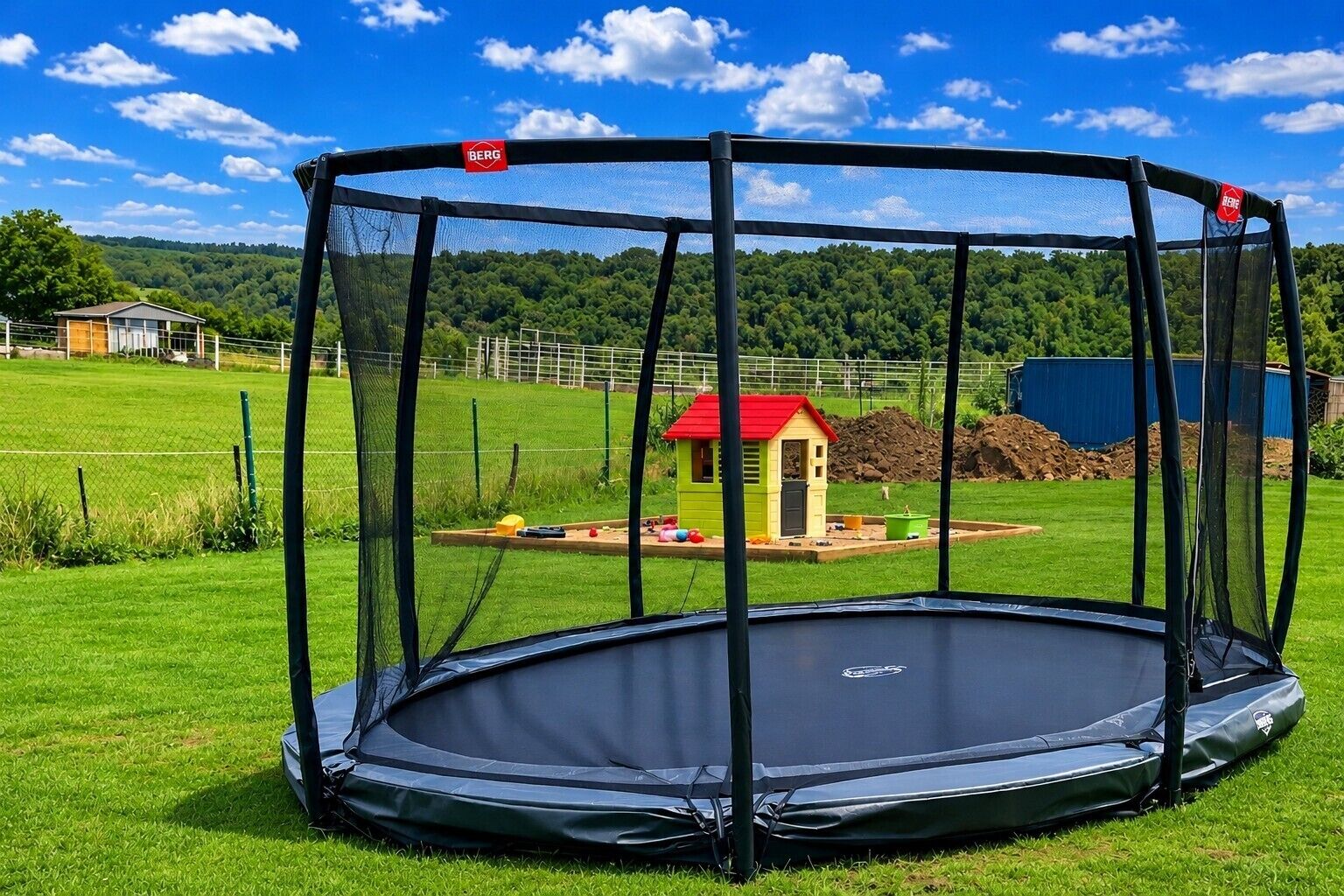 A trampoline with a safety net enclosure in a grassy area.
