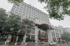 A multi-story hotel with a large entrance and a prominent sign. - Xiushan Yaxi Hotel (Xiushan Railway Station) (Xiushan County)