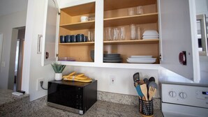 Una cucina con armadi a incasso, un forno a microonde e un portauova.