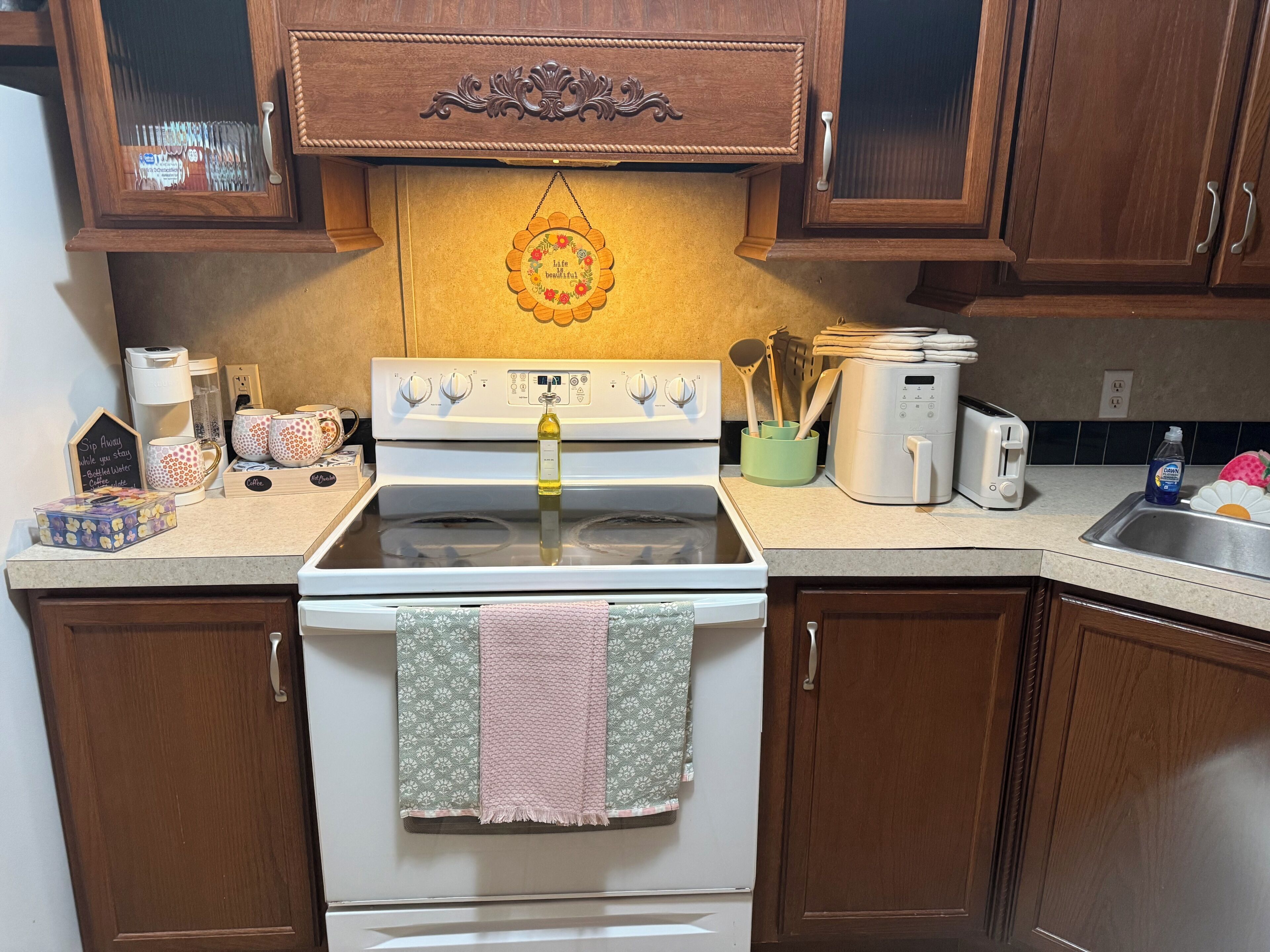 Una cocina con estufa, cafetera y tostadora.