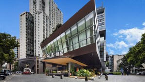 Un hôtel moderne doté d’une entrée imposante, de grandes fenêtres et d’un espace de stationnement.