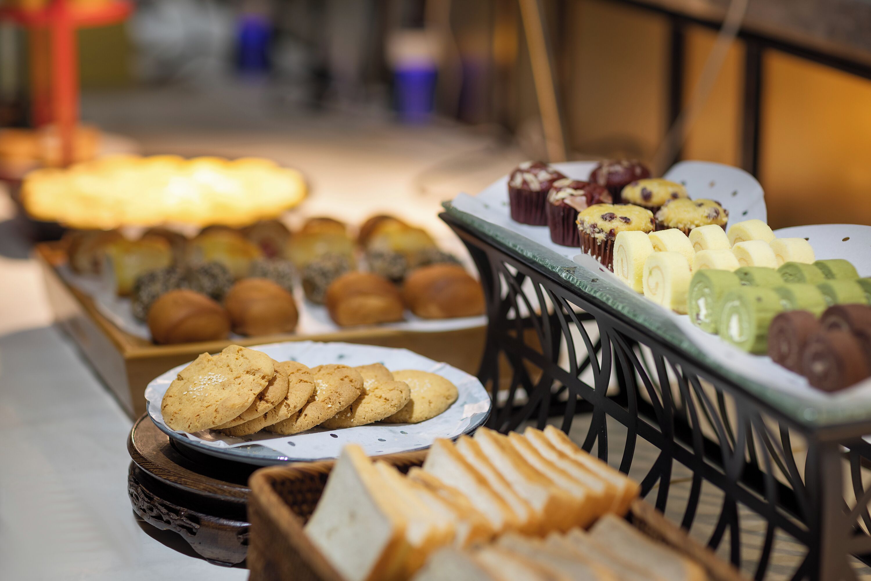 A variety of baked goods displayed on a table, including cookies, muffins, and bread.