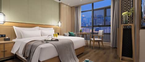 Habitación de hotel con una cama grande, un escritorio y vistas a la ciudad.