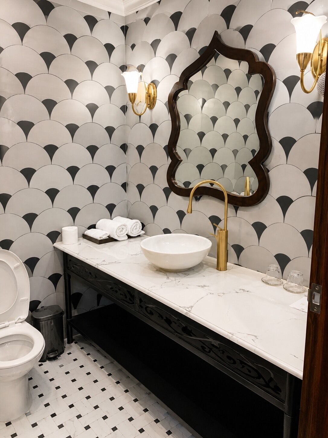Un baño con lavamanos blanco, un espejo y un inodoro.