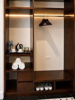 A walk-in closet with shelves, a hanging rack, and a shoe rack.