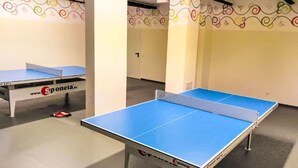 Un tavolo da ping pong con superficie di gioco blu e rete, e un tavolo da tennis tavolo con superficie di gioco bianca e rete, entrambi marchiati 'Sponeta'.