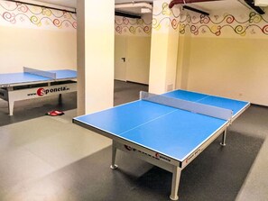 Ein Tischtennis-Tisch mit blauer Spielfläche und Netz, sowie ein weiterer Tisch mit weißer Spielfläche und Netz, beide mit dem Schriftzug 'Sponeta'.