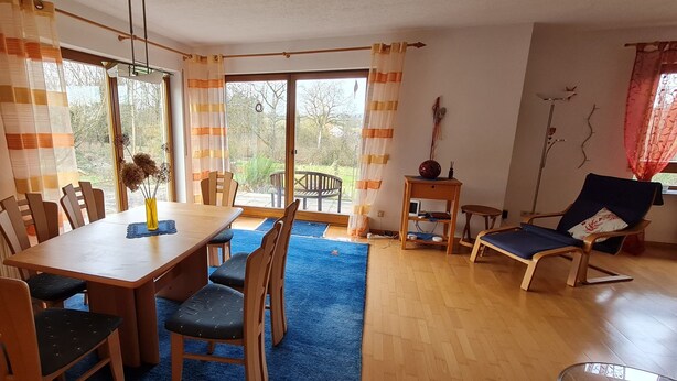 Comedor con mesa, sillas y vista al exterior.