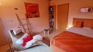 Un dormitorio con cama, estantería, escalera y una obra de arte colgada en la pared.