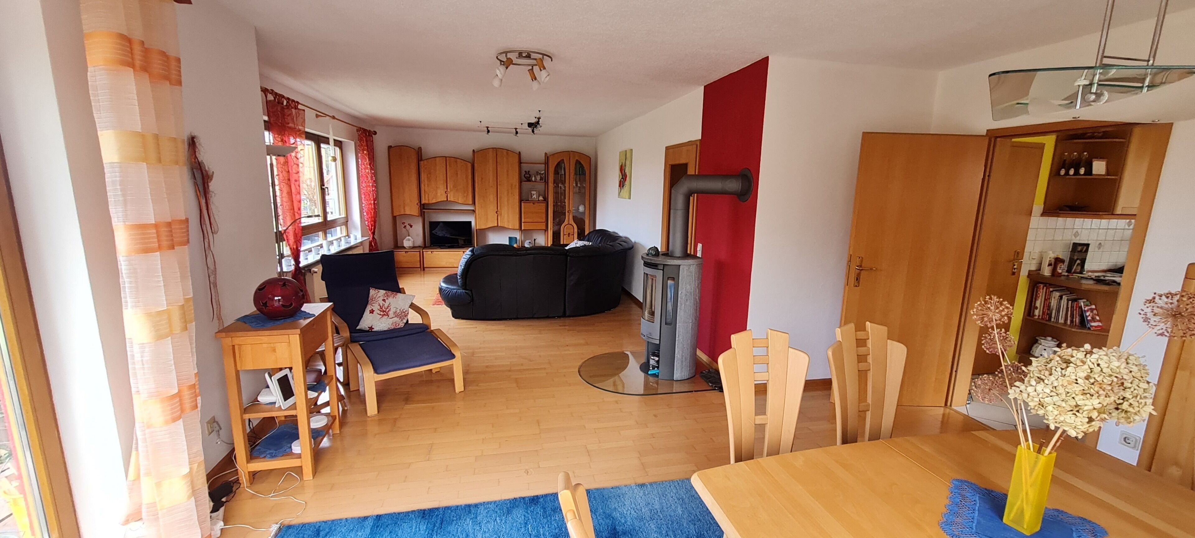 A living room with a fireplace, wooden furniture, and a dining area with a table and chairs.