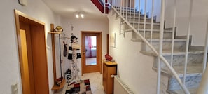 A hallway with a staircase leading to a landing.