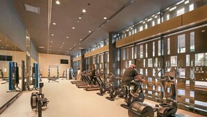 Ein Fitnessstudio mit Laufbändern, Kraftgeräten und Trainingsausrüstung.