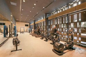 A gym with treadmills, weight machines, and exercise equipment. - Stylish Modern 2B Apt w/ Pool, Gym, View & Library (Docklands)