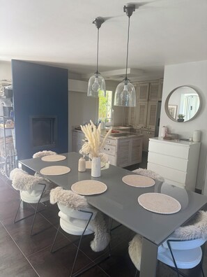 Uma zona de refeições moderna com uma mesa grande, cadeiras e detalhes decorativos.