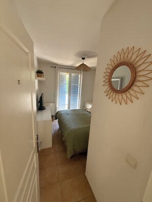 A bedroom with a bed, a bedside table, a hanging light fixture, and a wall-mounted mirror. - House with a View of the Castle • Jacuzzi • Fire pit • Fitness Area • Beaches 10 minutes away (Cogolin)