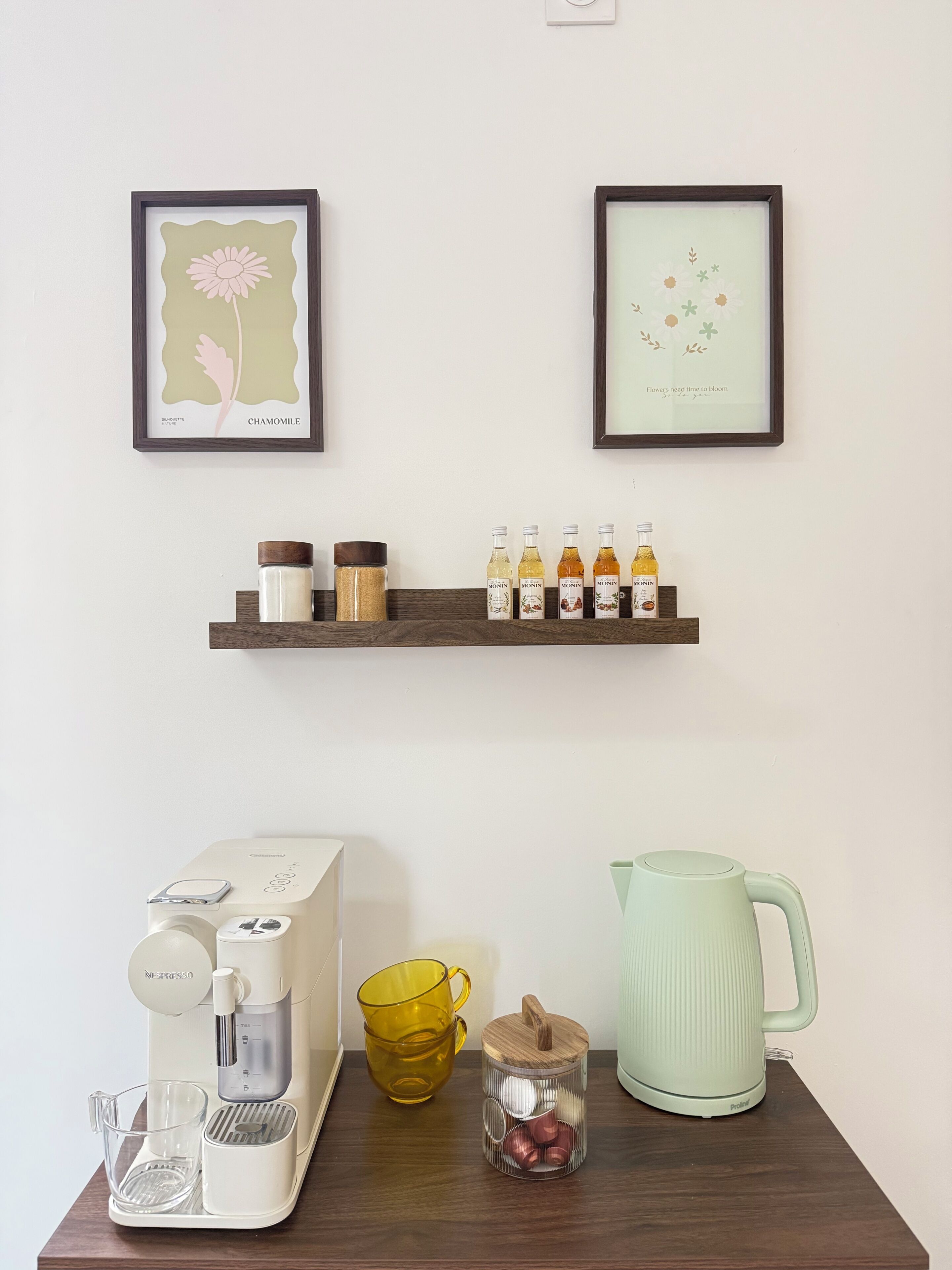 A kitchen counter with a coffee maker, a kettle, a mug, and a spice rack.