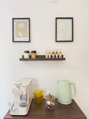A kitchen counter with a coffee maker, a kettle, a mug, and a spice rack.