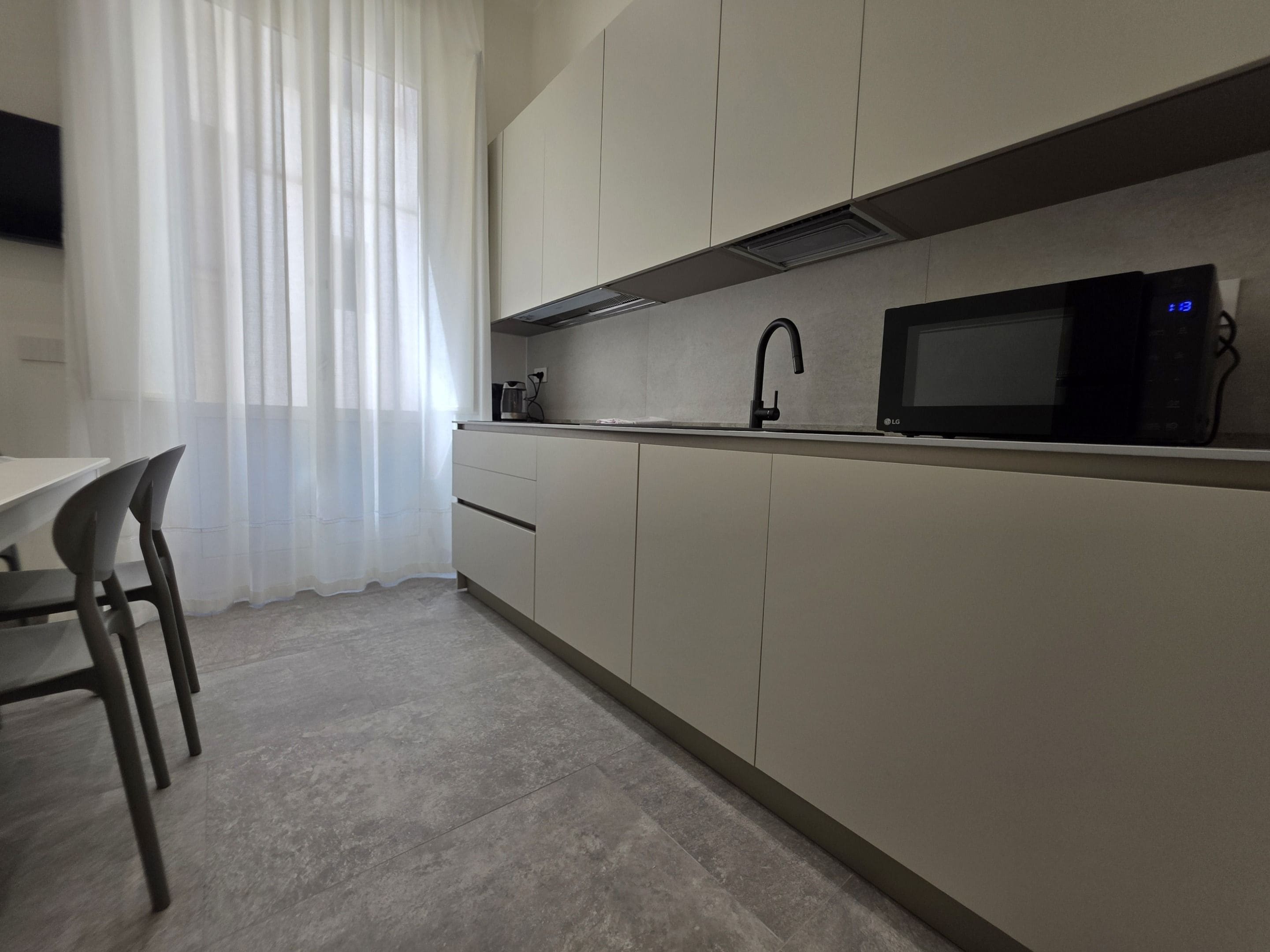 A modern kitchen with a microwave, sink, and cabinets.