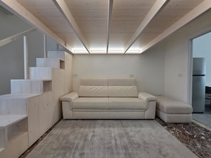A modern interior with a sofa, built-in shelving, and a large window. - Domus Arconti (Reggio Calabria)